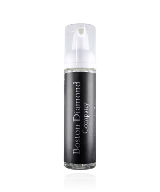 A clear plastic bottle with a white pump, filled with all natural foam jewelry cleaner, labeled 'Boston Diamond Company'